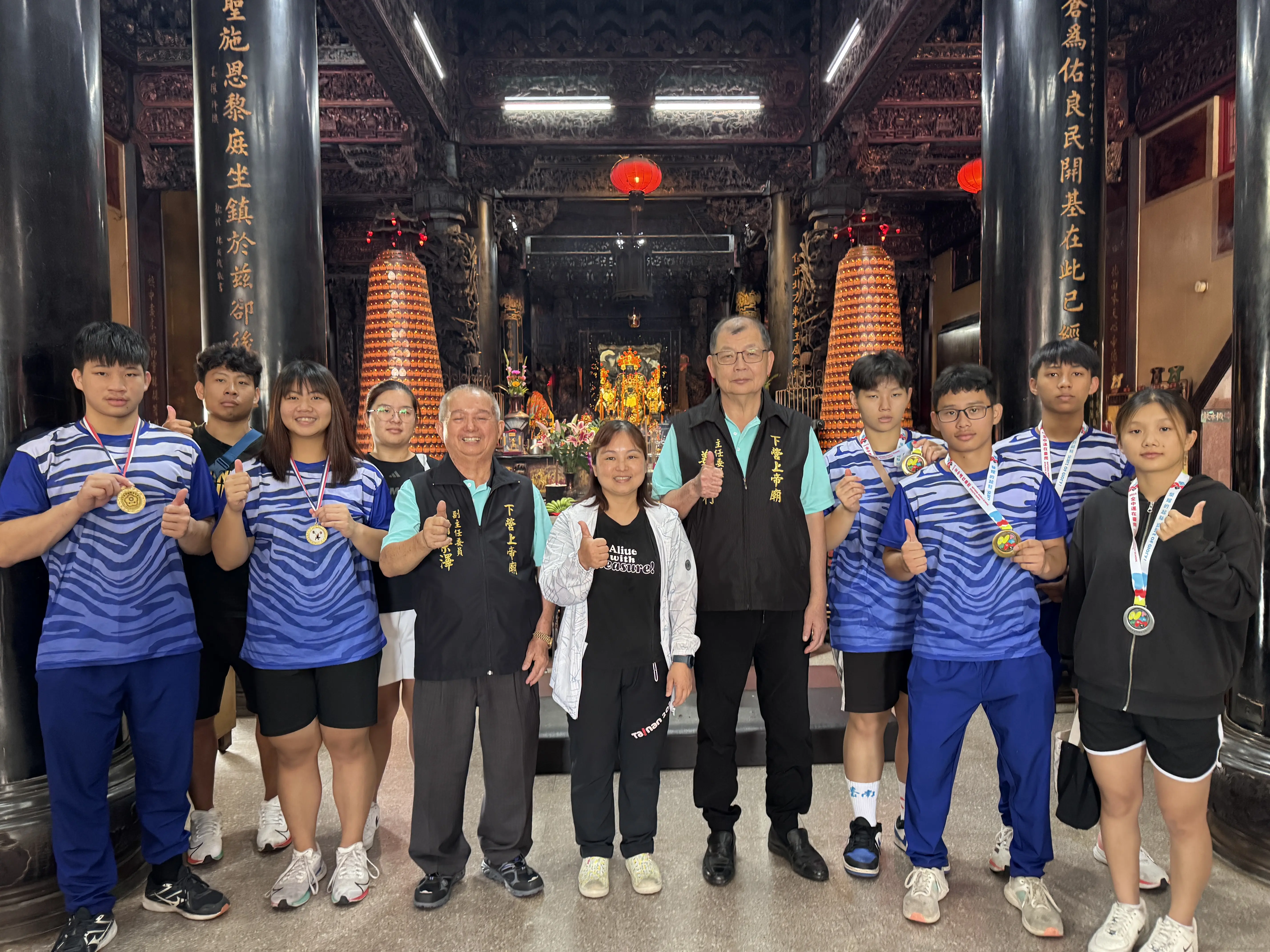 陳涵彤教練（中）帶領大內國中舉重隊，來到玄天上帝座前，將114年全國中等學校運動會得獎與眾神及管理委員會分享。（劉采妮拍攝）